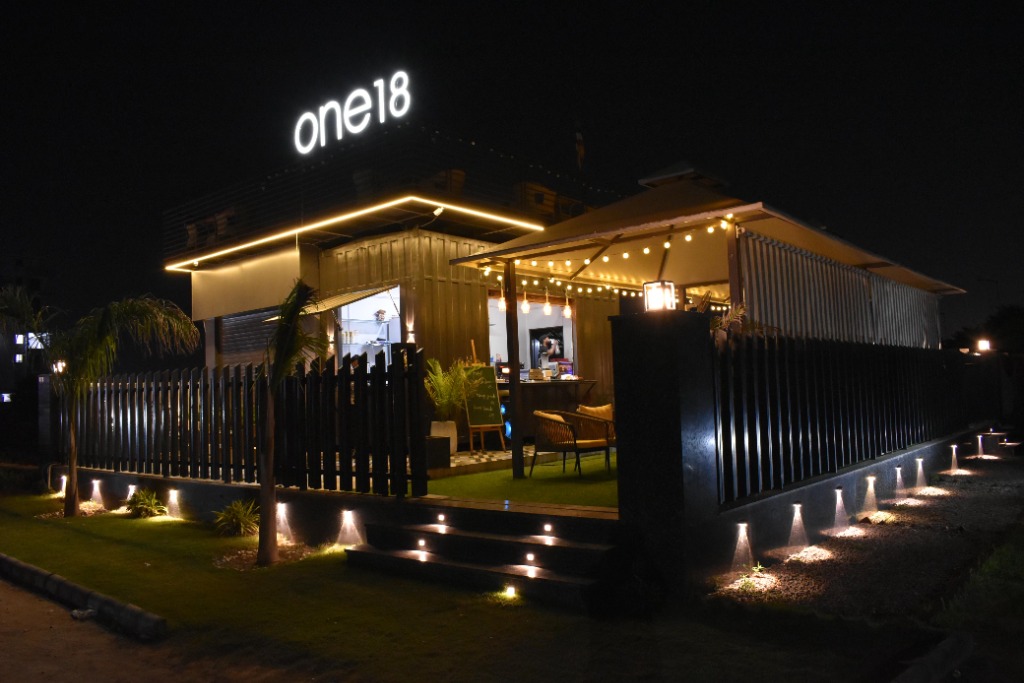 One18 Cafe exterior at night with glowing neon sign